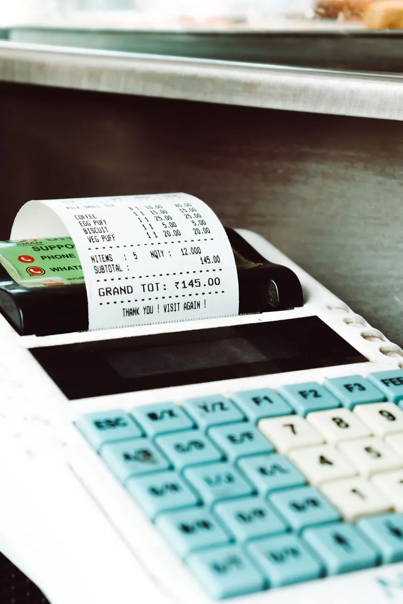 Caja registradora imprimiendo un ticket de papel térmico en un comercio